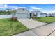 Gray house with red shutters, driveway, and grassy yard at 356 Citrine Loop, Kissimmee, FL 34758