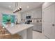 Modern kitchen with gray cabinets, quartz countertops, and island seating at 356 Citrine Loop, Kissimmee, FL 34758