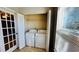 Bright laundry room with washer, dryer, and built-in shelving at 5773 Gatlin Ave # 627, Orlando, FL 32822