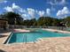 Community pool with brick deck and lounge chairs at 5773 Gatlin Ave # 627, Orlando, FL 32822