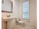 Small bathroom with pedestal sink, toilet, and window at 10090 Sunnifa Aly, Orlando, FL 32832