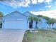Light blue house with a two-car garage and landscaped yard at 2907 Delcrest Dr, Orlando, FL 32817