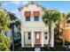 Bright yellow house with orange accents, palm trees, and a brick walkway at 3075 Key Lime Loop, Kissimmee, FL 34747