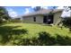 Large backyard with grassy lawn and sliding glass door access at 468 Andalusia Loop, Davenport, FL 33837