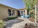 Private backyard patio with brick pavers, two blue chairs, and a garden arch at 516 Millifiora Ln, Kissimmee, FL 34759