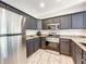 Modern kitchen boasts dark cabinetry, stainless steel appliances, and granite countertops at 7510 Seven Eagles Way # 7510, Reunion, FL 34747