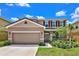 Two-story home with a large garage and landscaped yard at 7635 Oakmoss Loop, Davenport, FL 33837