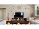 Elegant living room featuring a large TV, comfortable seating, and stylish decor at 7635 Oakmoss Loop, Davenport, FL 33837