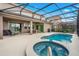 Relaxing pool and spa area with covered patio and lounge chairs at 7635 Oakmoss Loop, Davenport, FL 33837