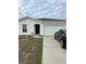 White house with a two-car garage and a black car parked in the driveway at 106 Orchid Ct, Kissimmee, FL 34759
