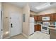 Kitchen features wood cabinets, white appliances, and breakfast bar at 3176 Feltrim Pl # 102, Kissimmee, FL 34747