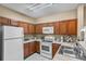 Well-equipped kitchen with wood cabinets and stainless steel sink at 3176 Feltrim Pl # 102, Kissimmee, FL 34747