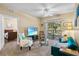 Cozy living room with teal sofa, comfortable armchair, and sliding glass doors to patio at 3176 Feltrim Pl # 102, Kissimmee, FL 34747
