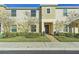 Two-story townhome with light beige siding, landscaping, and a paved walkway at 439 Annabelle Way, Davenport, FL 33837