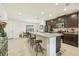 Open kitchen features dark wood cabinets, granite island, and stainless steel appliances at 439 Annabelle Way, Davenport, FL 33837