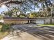 Ranch style home exterior with a red door and attached garage at 5100 Helen Ct, St Cloud, FL 34772