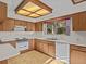 Kitchen with wood cabinets, white appliances, and a window at 5100 Helen Ct, St Cloud, FL 34772
