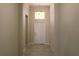 A light-colored hallway with tile floors and a white door at 1569 Thetford Cir, Orlando, FL 32824
