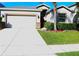 One-story house with a white garage door and a red front door at 1569 Thetford Cir, Orlando, FL 32824