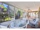 Bright sunroom with glass walls, white furniture and tiled floor at 169 Tall Pines Pass, Kissimmee, FL 34759