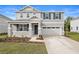 Two-story house with gray siding, stone accents, and a two-car garage at 670 Summit River Dr, Apopka, FL 32712