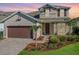 Two-story house with brown garage door and landscaping at 674 Anna Ridge Rd, Minneola, FL 34715