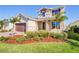 Two-story house with stone accents, a brown door and landscaped yard with palm trees at 674 Anna Ridge Rd, Minneola, FL 34715