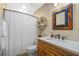 Clean bathroom with shower/tub combo, vanity with quartz countertop and decorative mirror at 729 Main Street, Windermere, FL 34786