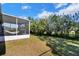 Spacious backyard with a screened porch and lush landscaping at 905 Gascony Ct, Kissimmee, FL 34759