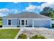 Newly built home with gray exterior, two-car garage, and well-maintained lawn at 905 Gascony Ct, Kissimmee, FL 34759