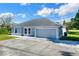 Newly built home with gray exterior, two-car garage, and well-maintained lawn at 905 Gascony Ct, Kissimmee, FL 34759