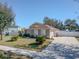 One-story house with a brown roof, gray siding, and a driveway at 1032 Tawny Eagle Dr, Groveland, FL 34736