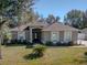 One-story house with a brown roof, gray siding, and a front yard at 1032 Tawny Eagle Dr, Groveland, FL 34736