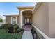 Front entry with a dark brown door and a landscaped walkway at 1032 Tawny Eagle Dr, Groveland, FL 34736