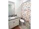 Clean bathroom with granite countertop, white vanity, and nautical shower curtain at 161 Andreas St, Winter Haven, FL 33881