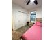 Bedroom with pink bedding, double door closet and nightstand at 161 Andreas St, Winter Haven, FL 33881
