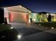 One-story house with brick pavers driveway and colorful nighttime lighting at 161 Andreas St, Winter Haven, FL 33881