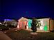 Night view of a one-story home with colorful lights and landscaping at 161 Andreas St, Winter Haven, FL 33881