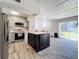 Modern kitchen with gray cabinets, quartz island, and stainless steel appliances at 163 Lewfield Cir, Winter Park, FL 32792