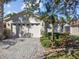 Tan one-story house with two-car garage, paved driveway, and landscaped yard at 200 Grand Canal Dr, Kissimmee, FL 34759
