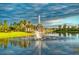 Water fountain in community lake with palm trees and lush landscaping at 200 Grand Canal Dr, Kissimmee, FL 34759