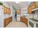 Kitchen with oak cabinets, white appliances, and tile floor at 200 Grand Canal Dr, Kissimmee, FL 34759