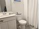 Simple bathroom with a white vanity, toilet, shower, and gray flooring at 2914 Scarlett Dr, Saint Cloud, FL 34772