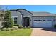 Attractive single-story home with gray siding, a two-car garage, and a brick driveway at 2914 Scarlett Dr, Saint Cloud, FL 34772