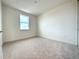 Simple bedroom with neutral colored carpet and large window at 9778 Bucklow Hill Dr, Orlando, FL 32832