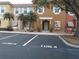 Two story townhome with tan and orange exterior, two parking spaces, and landscaping at 1064 Park Ridge Cir, Kissimmee, FL 34746