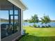 Screened porch overlooking a lake, with grill and plants at 249 Treviso Dr, Kissimmee, FL 34759