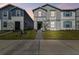 Two-story townhouses with gray and blue siding, brick paver path, and well-manicured lawn at 4186 Lana Ave, Davenport, FL 33897