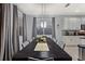 Formal dining room features a large table with gray chairs and modern light fixtures at 4449 Shiva Loop, Kissimmee, FL 34746