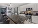 Modern kitchen features granite countertops, white cabinets, and a large island with bar seating at 4449 Shiva Loop, Kissimmee, FL 34746